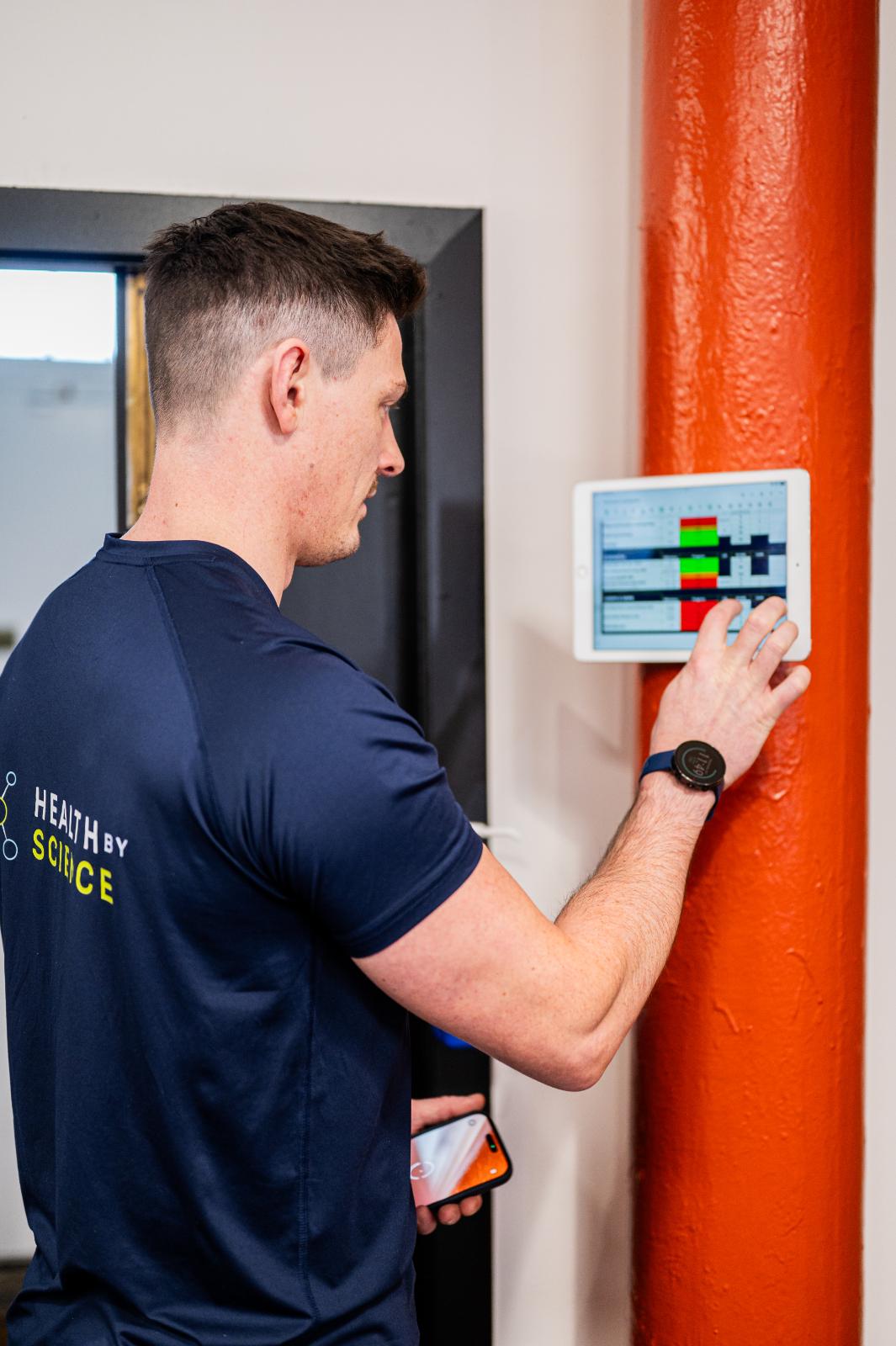 Health by Science specialist updating a clinical performance dashboard during a personal training Edinburgh session in Leith.