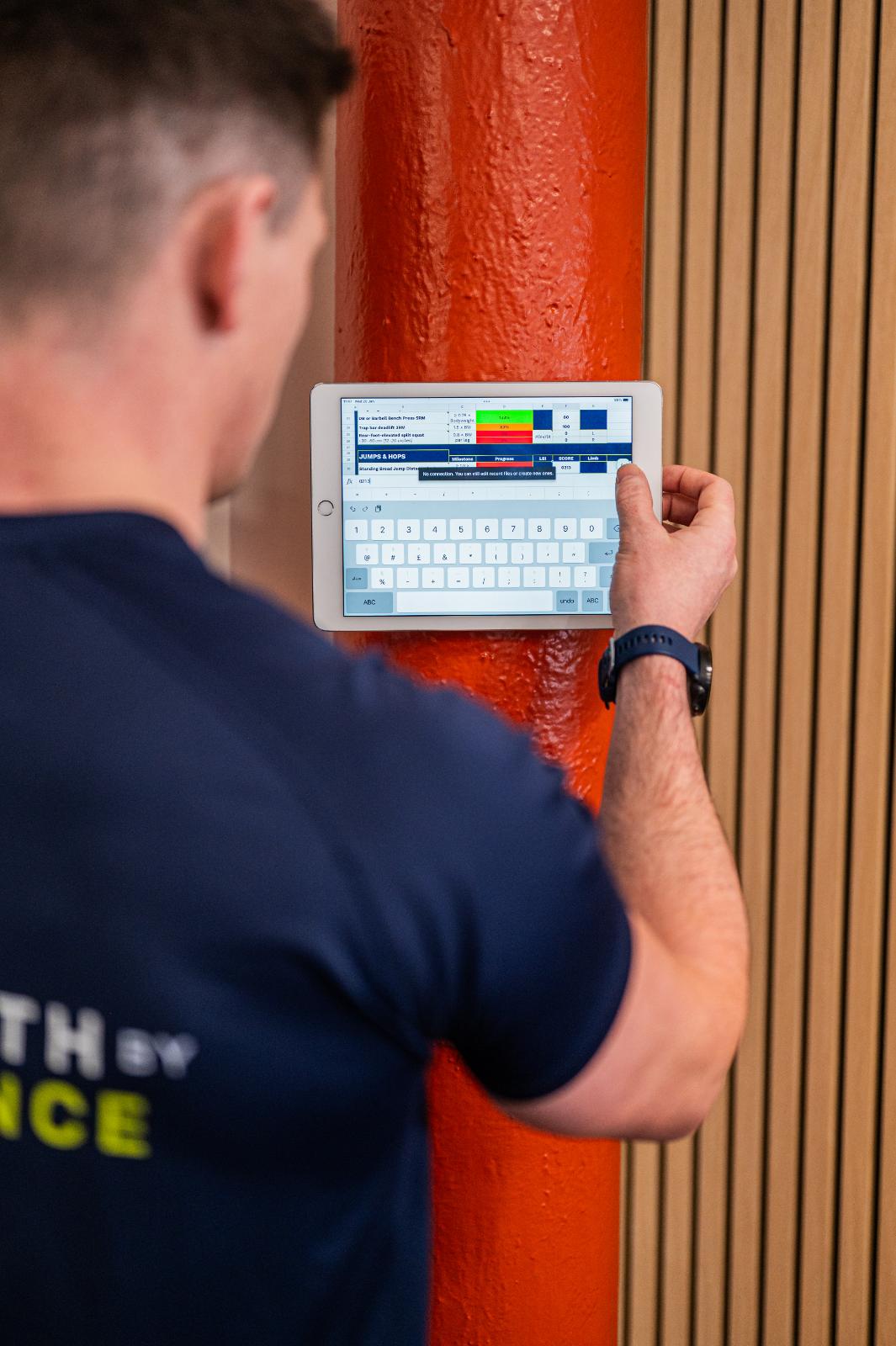 Close-up of a wall-mounted tablet used for tracking clinical biometrics and progress for personal training Edinburgh clients.