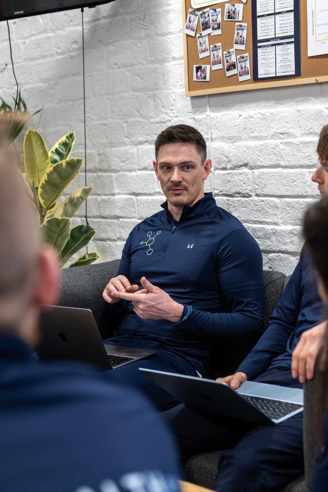 Clinical specialist explaining biomechanical assessment data during a team consultation at our Leith gym.