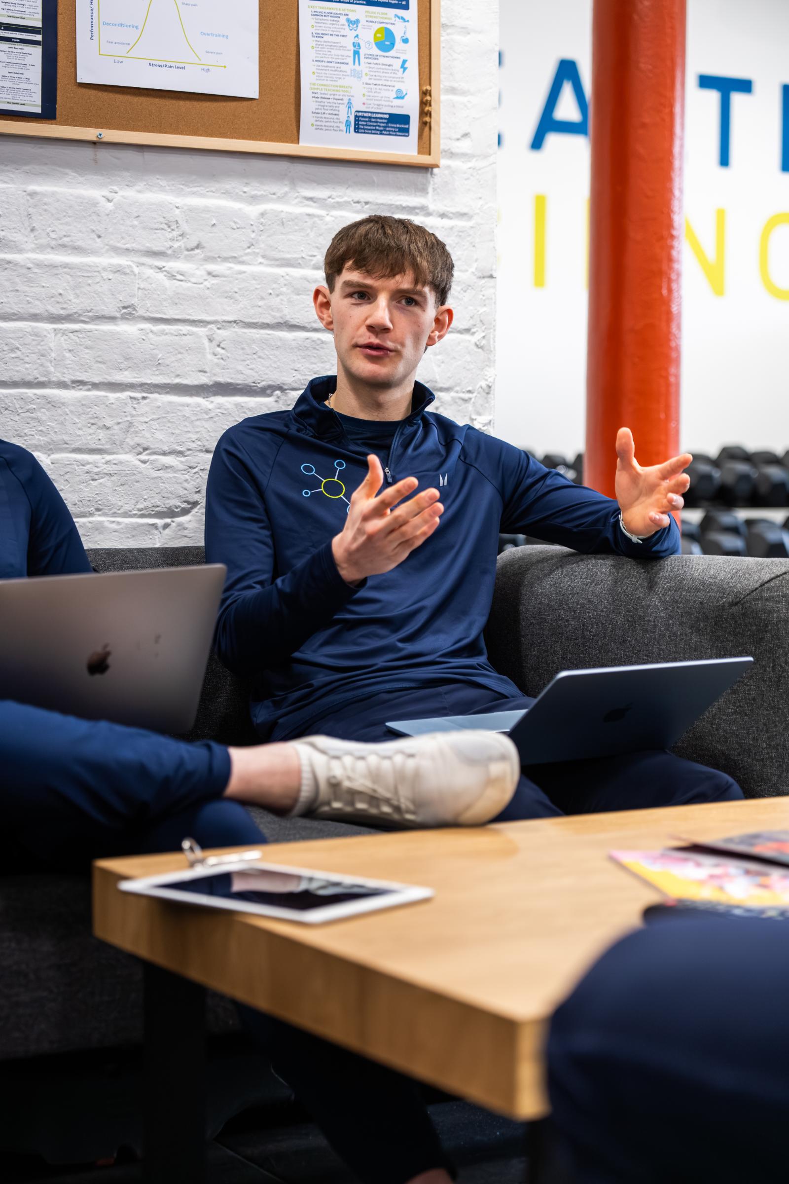 Practitioner explaining evidence-based training methodologies during a clinical team meeting at the Health by Science Leith lab.