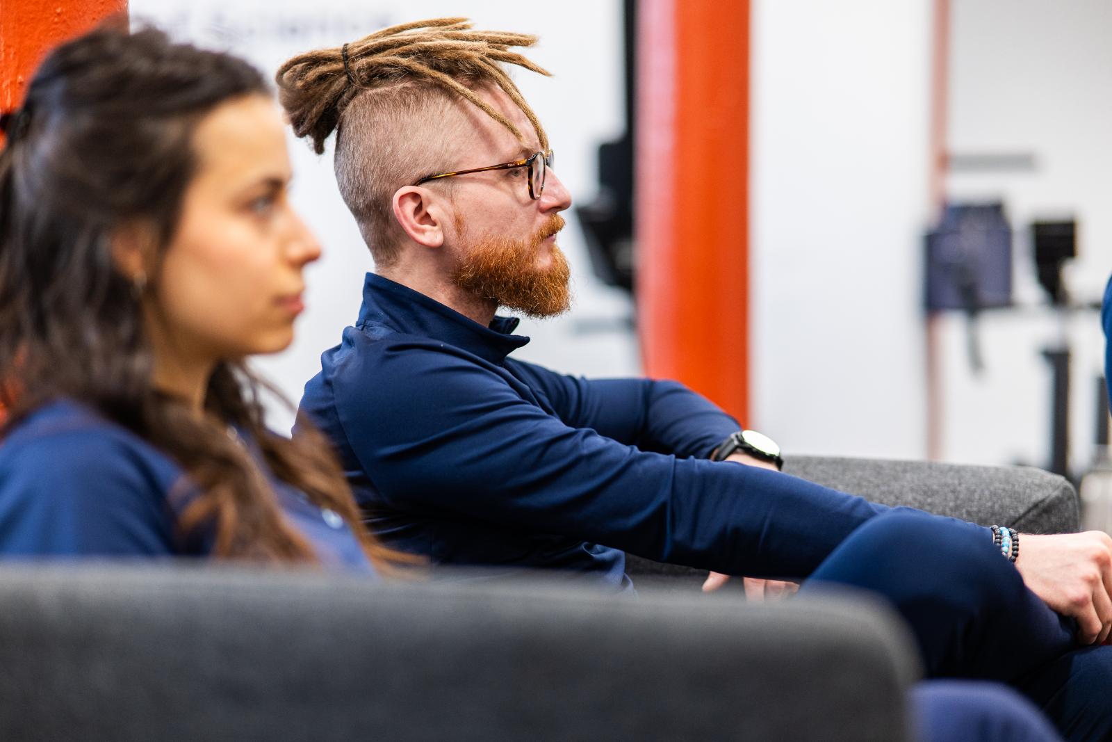 Health by Science staff member listening to a clinical presentation on patient rehabilitation progress in our Leith clinic.