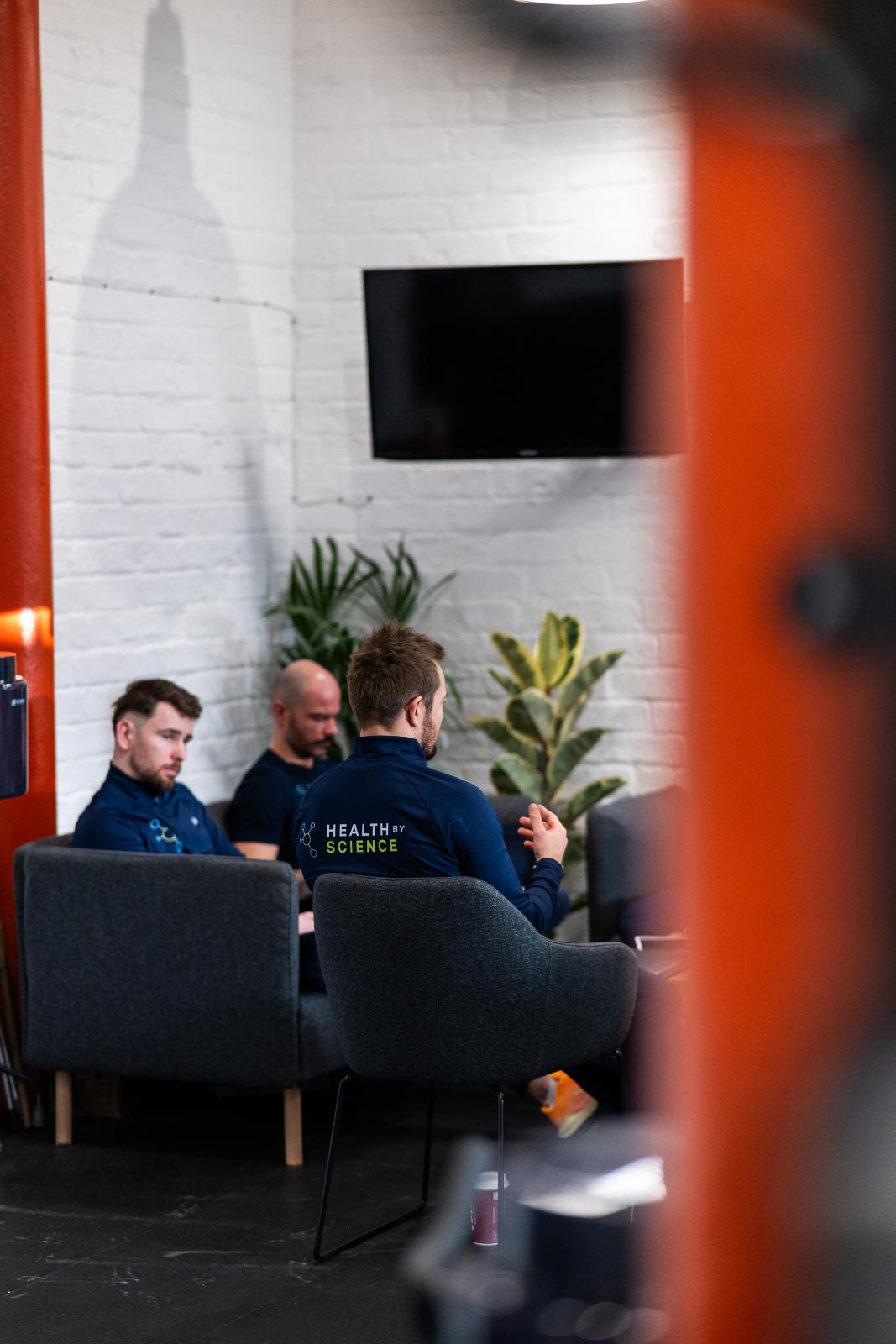 Members of the Health By Science team sitting in a comfortable lounge area, emphasizing the social and professional community of the Edinburgh-based enterprise.
