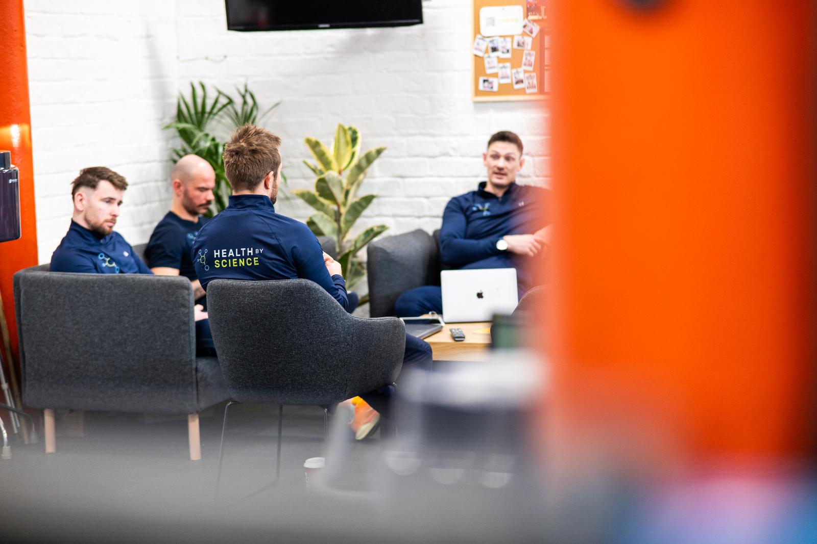 Clinical staff collaborating on injury prevention strategies during a professional development session at Health by Science Leith.