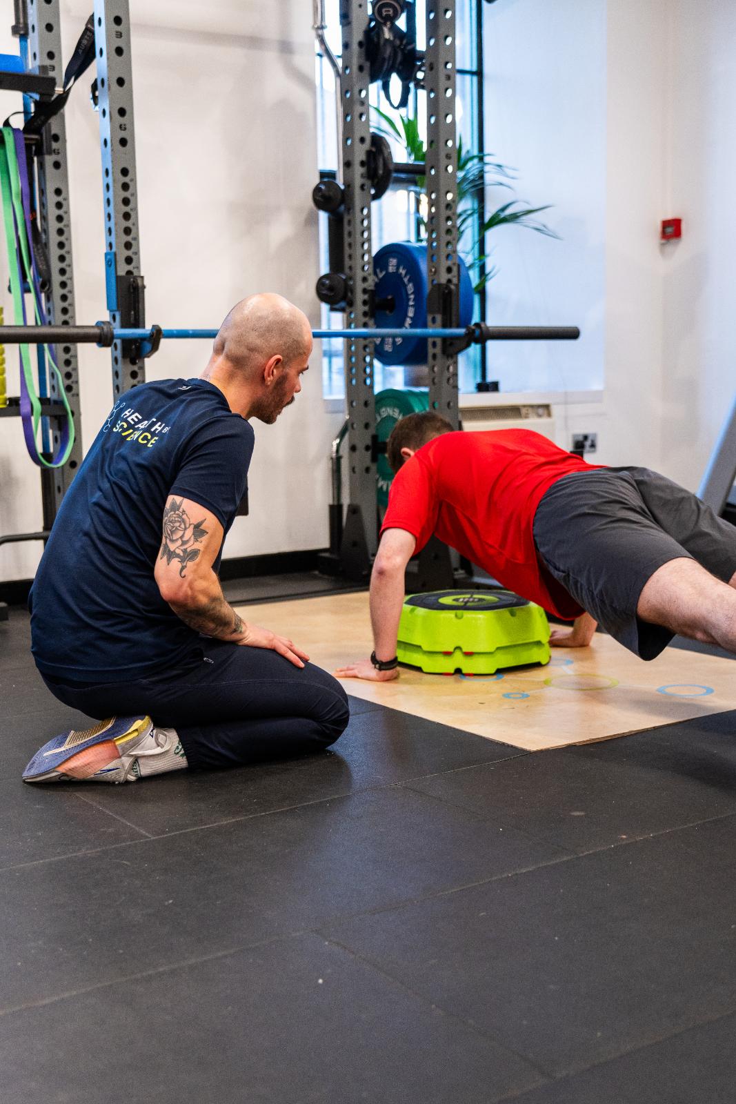 Clinical supervision of a push-up assessment using a balance trainer to assess core and upper body stability.