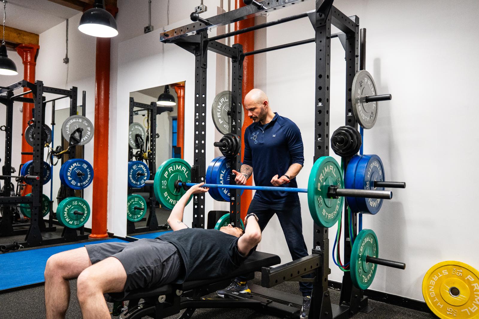 Health by Science practitioner demonstrating clinical lifting cues for a chest press exercise in our specialized Edinburgh lab.