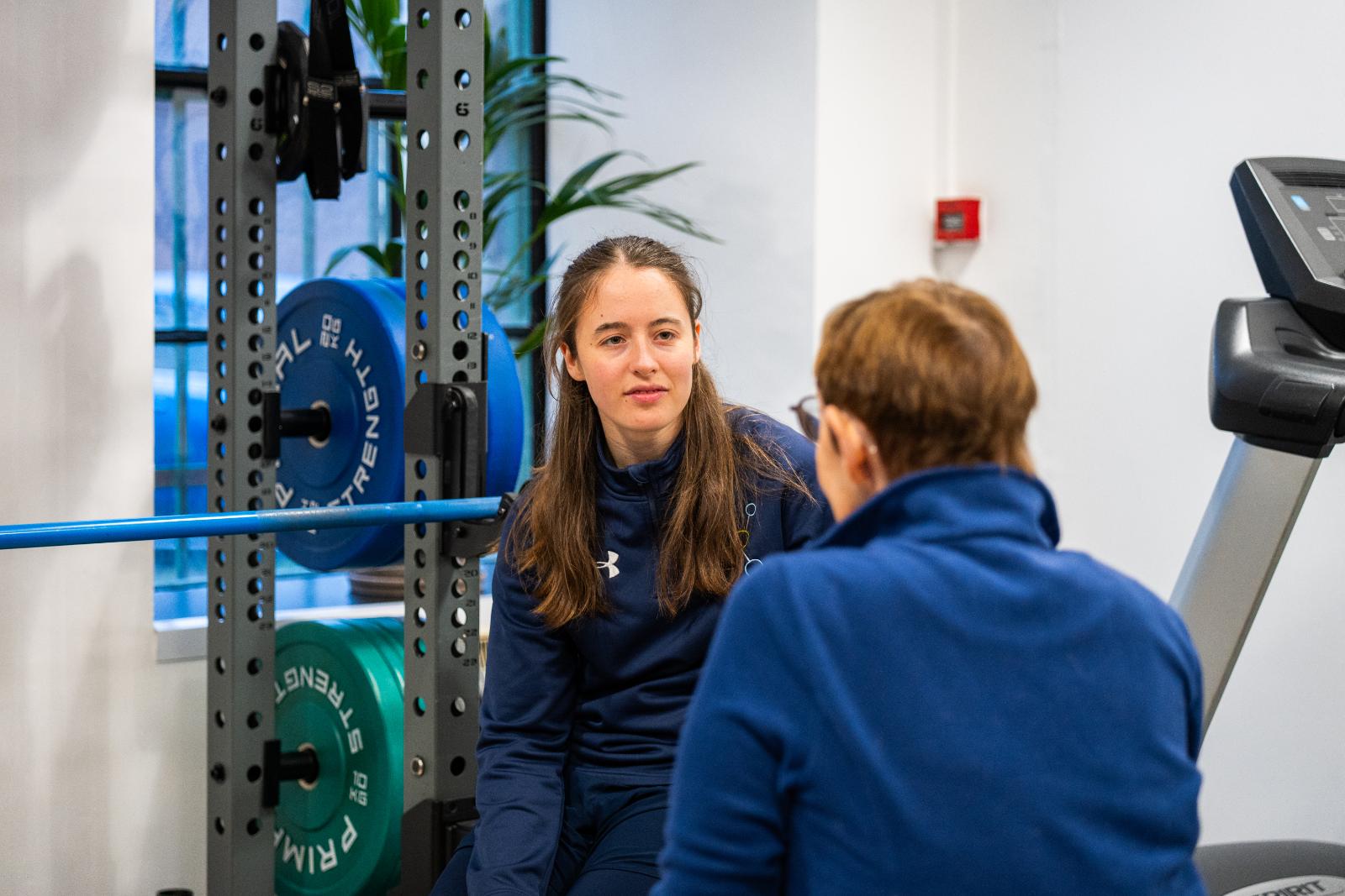 A female physiotherapist providing 1-to-1 guidance to a client during a structured rehab assessment.