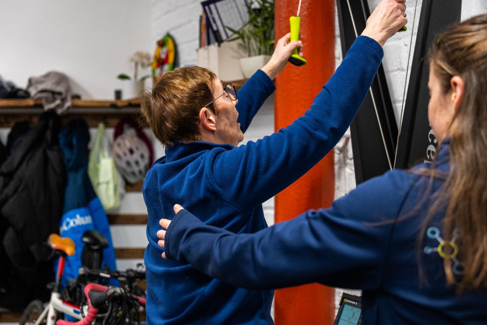 Specialist monitoring upper body mobility and pulling mechanics during a clinical rehabilitation session in our specialized Leith gym.