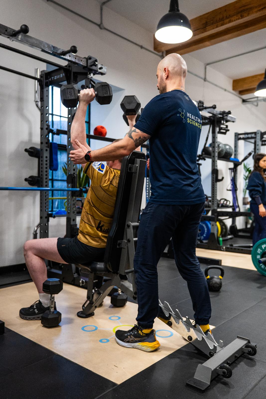Health by Science specialist providing technical feedback on overhead pressing mechanics during a personal training Edinburgh session.
