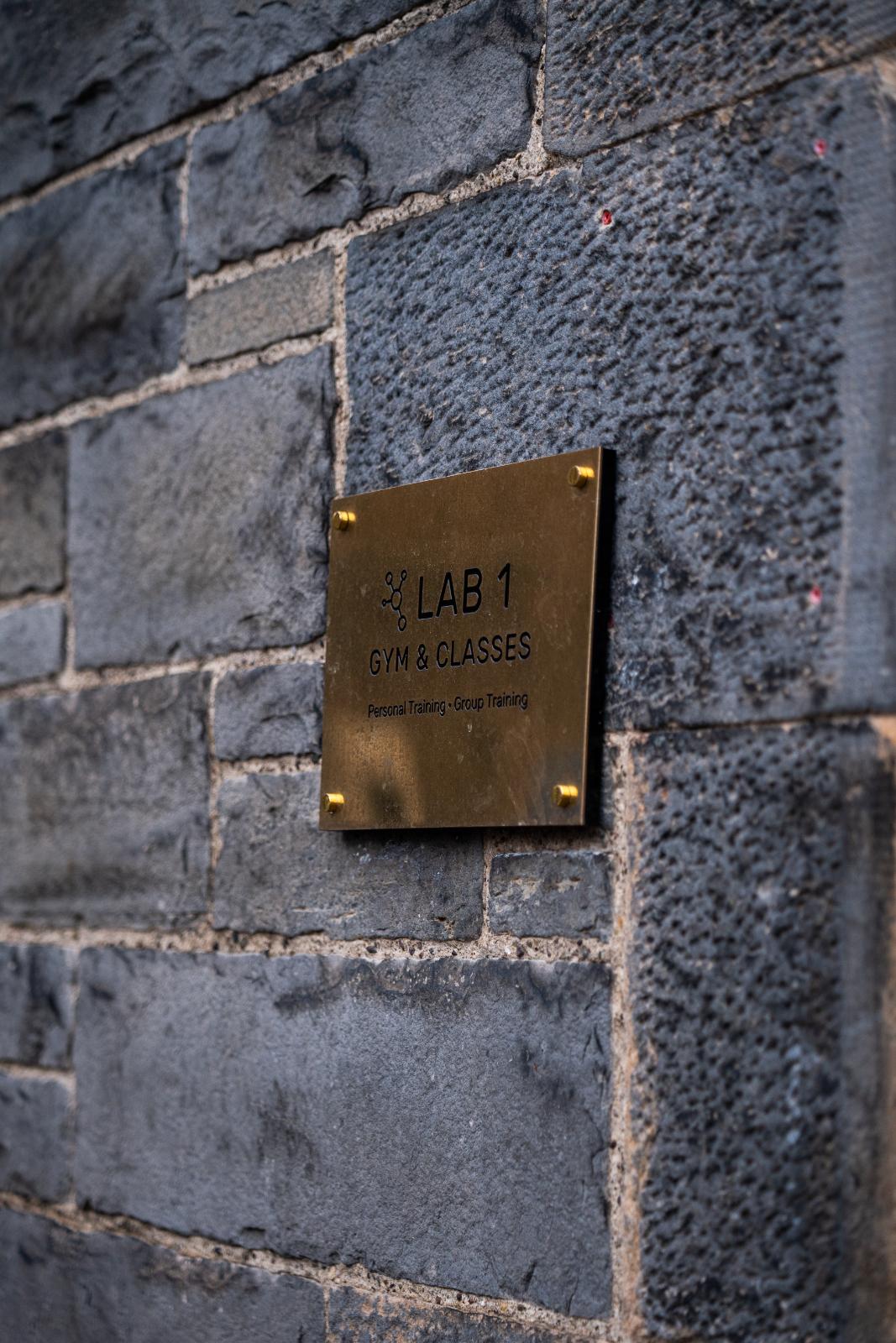 Close-up of the professional gold-plated signage for Lab 1 Gym & Classes at our clinical facility on Giles Street, Leith.
