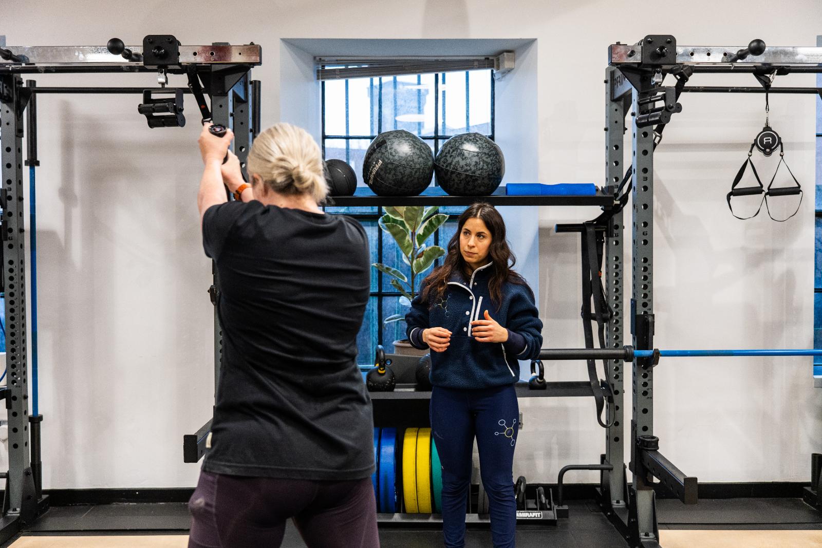 Specialist providing technical instruction for a functional pulling movement during a sports rehabilitation session at Health by Science Leith.