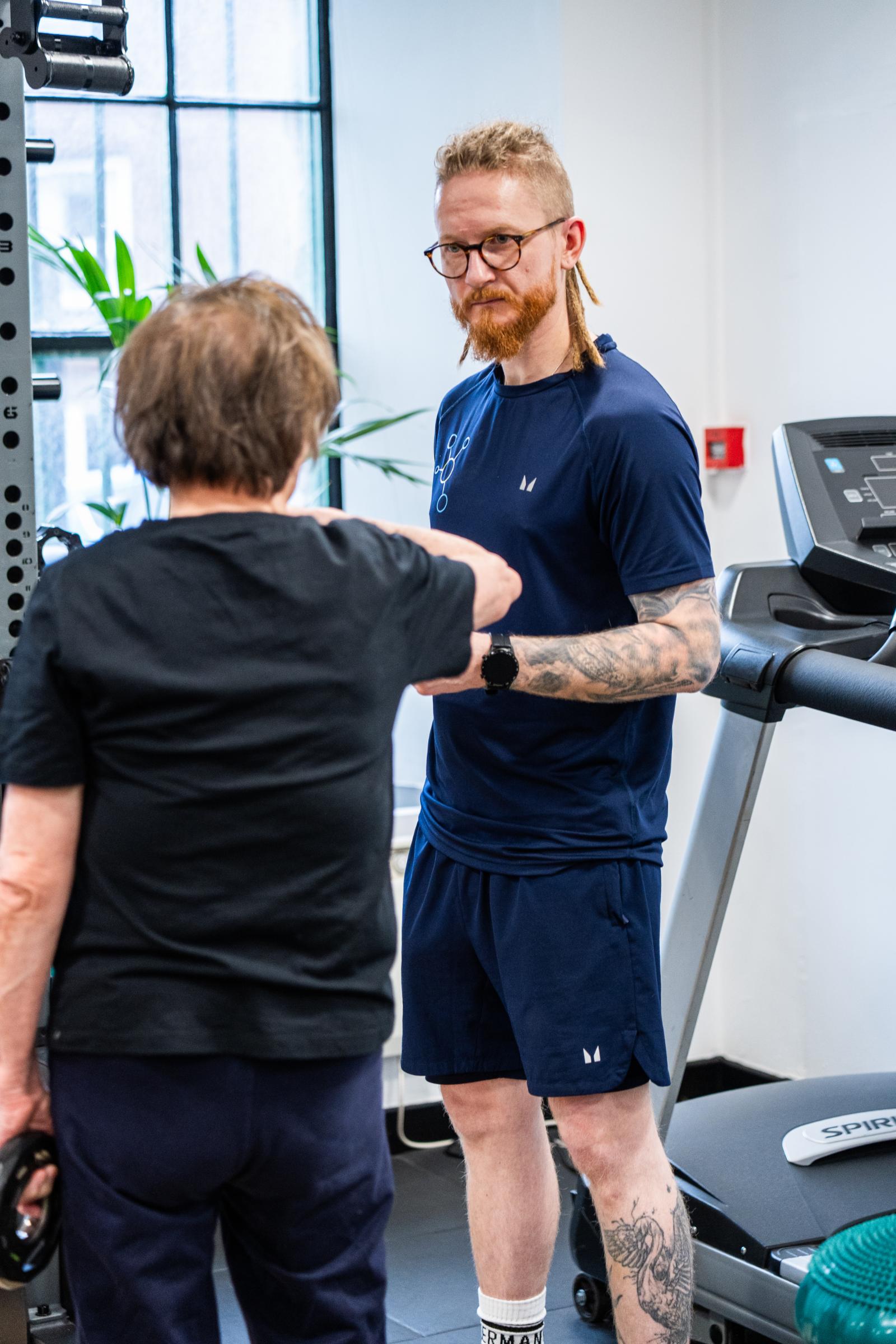 Specialist providing technical cues and movement analysis during a clinical rehabilitation session at our specialised Leith lab.