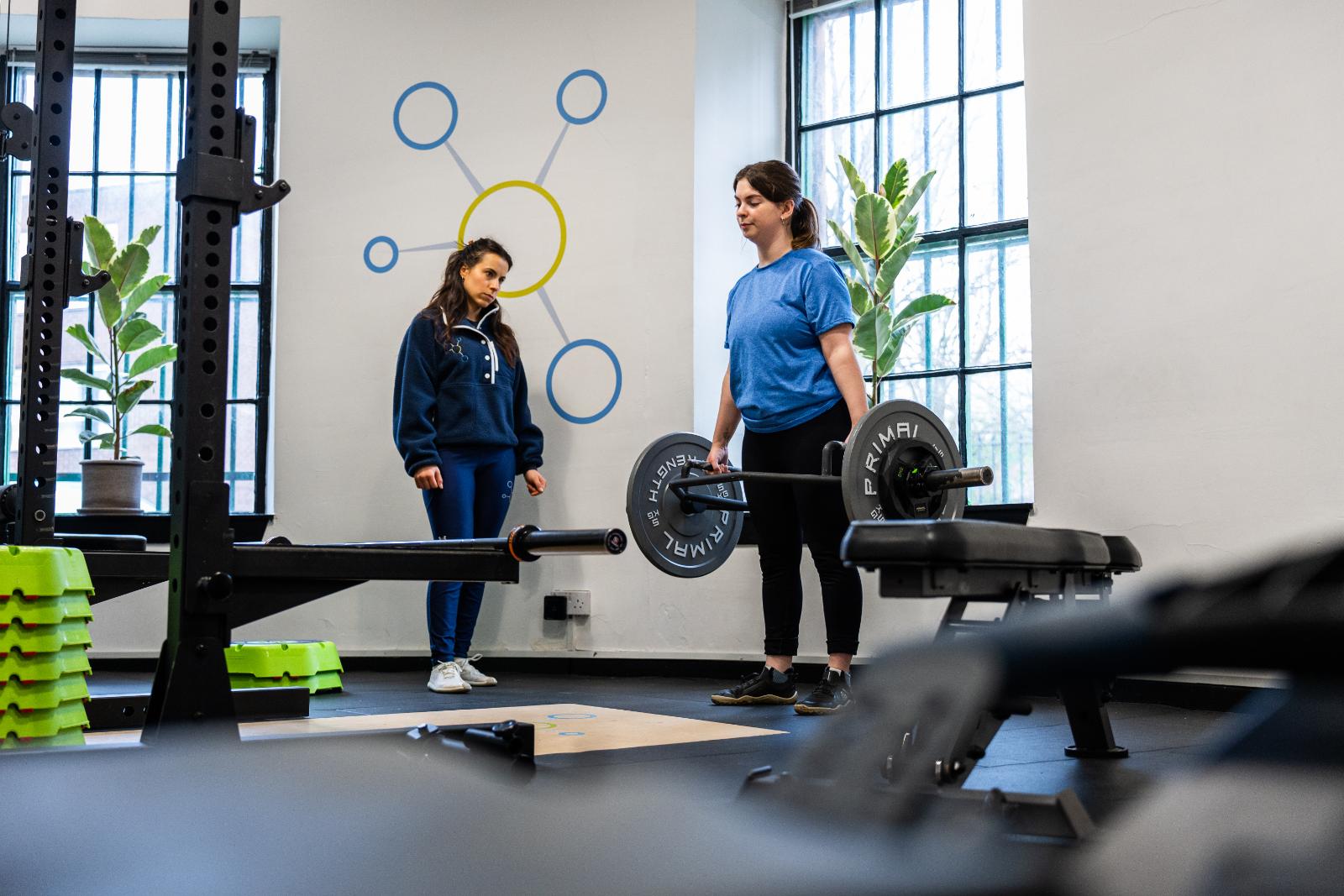 Professional monitoring of a trap bar deadlift setup to ensure safe hip hinge mechanics for a personal training Edinburgh client.