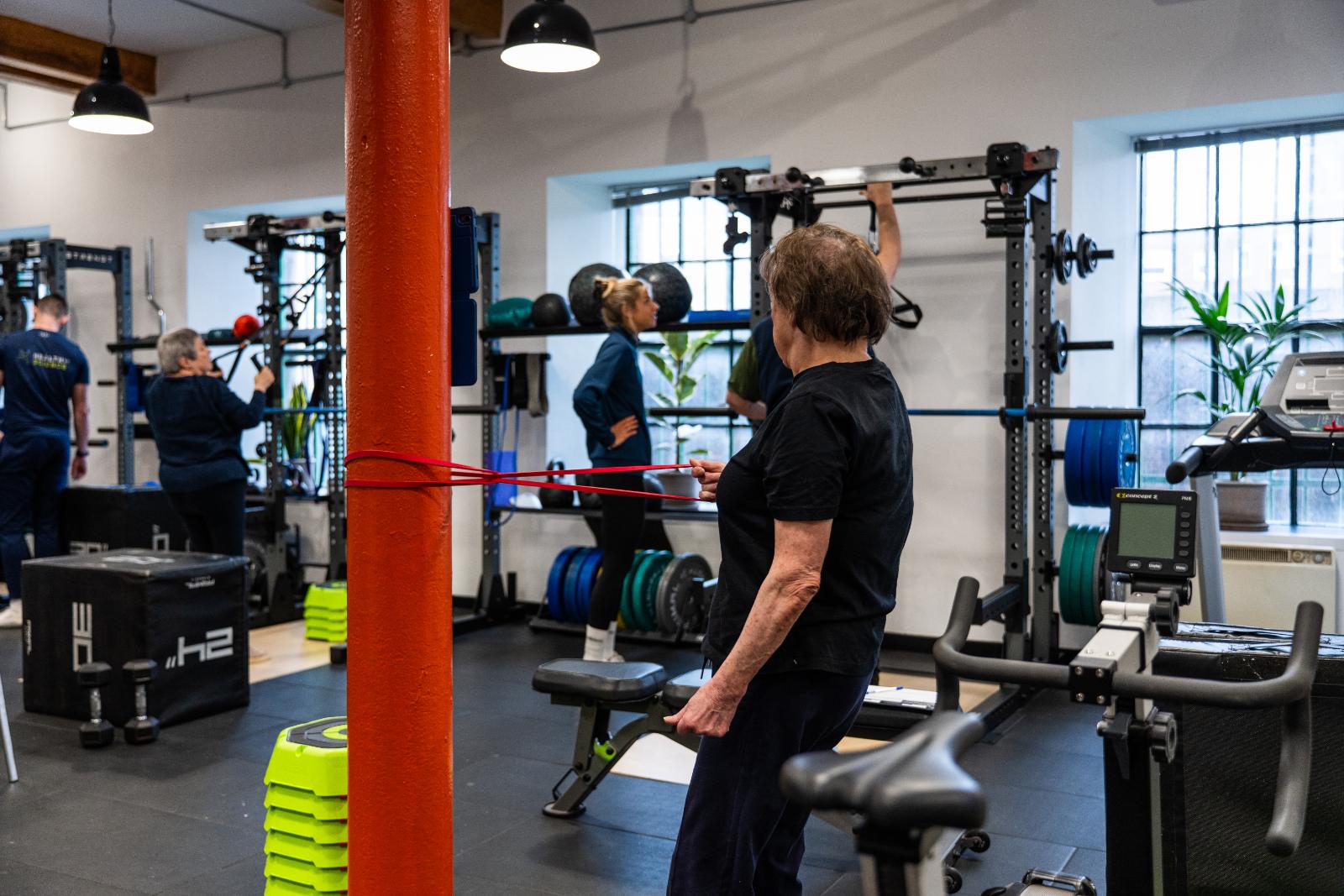 Clinical supervision of a resistance band movement assessment for a senior client at our specialised Leith rehabilitation gym.