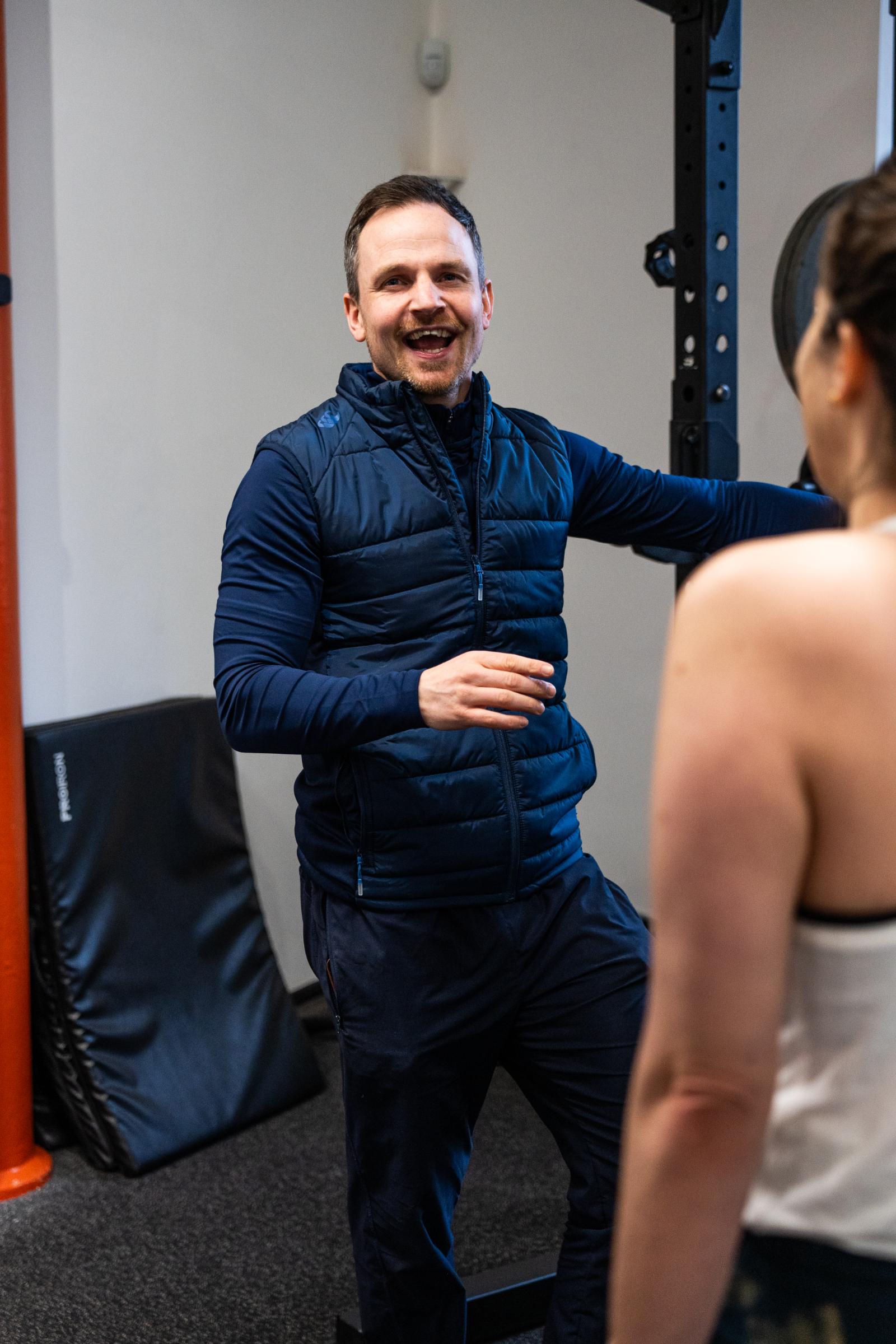 Portrait of a professional Health by Science coach providing positive reinforcement and encouragement during a clinical gym session.