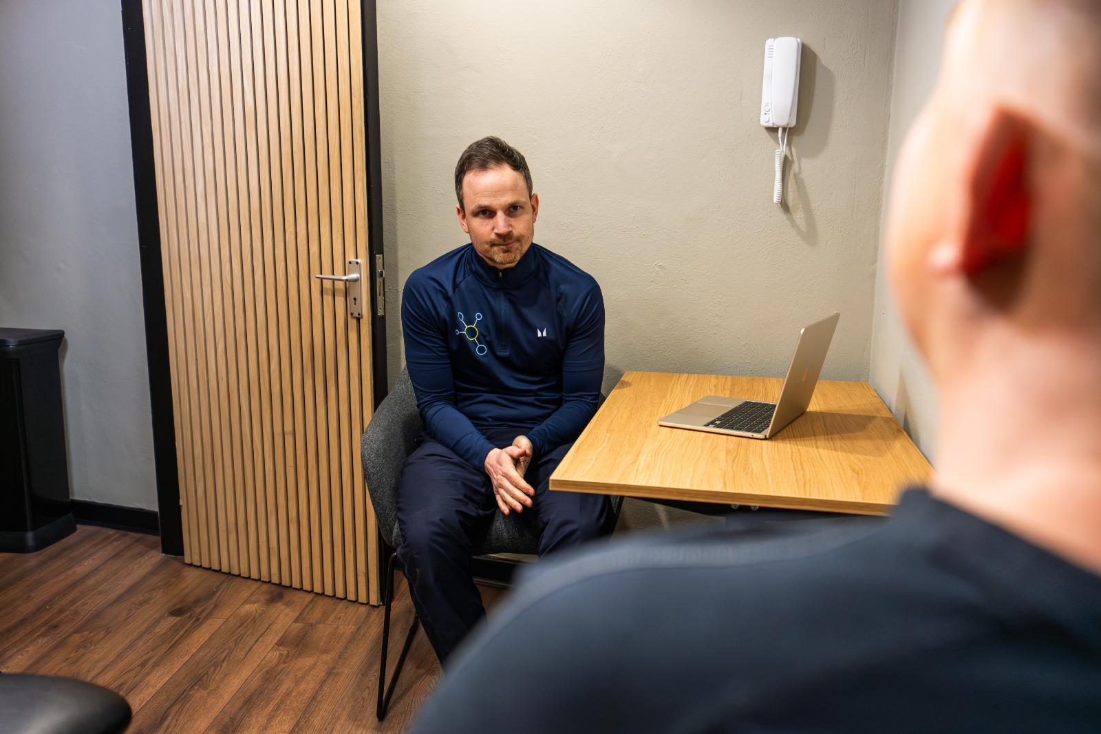 Practitioner explaining evidence-based treatment plans and injury recovery timelines during a patient consultation in Leith.