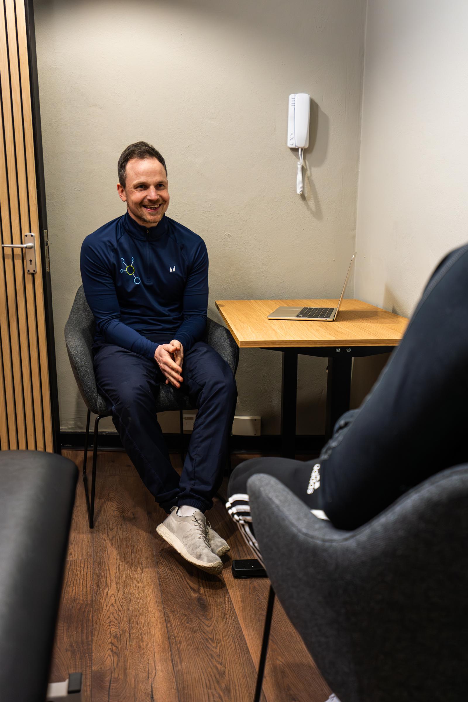 Specialist providing empathetic clinical advice and reviewing digital progress records with a patient in our Leith facility.