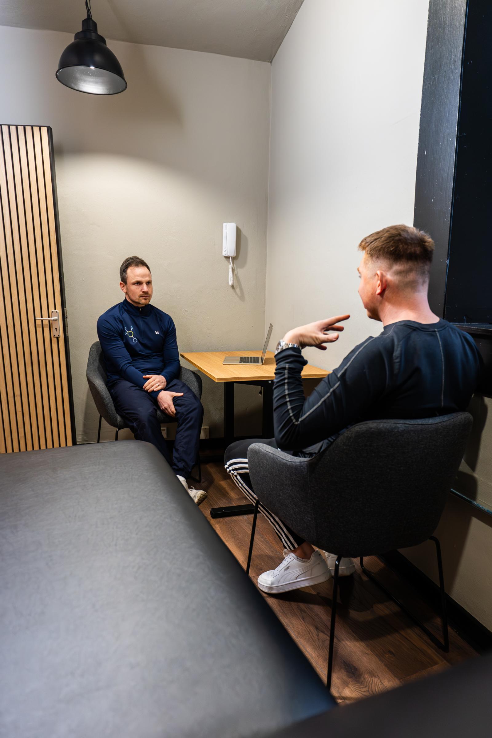 Focused patient intake and clinical assessment session within the professional treatment room at Health by Science Leith.