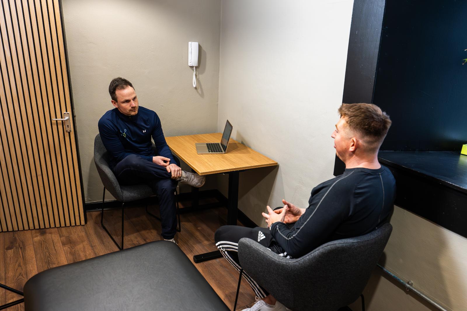 Private clinical consultation between a Health by Science specialist and a patient to discuss data-driven rehabilitation goals.