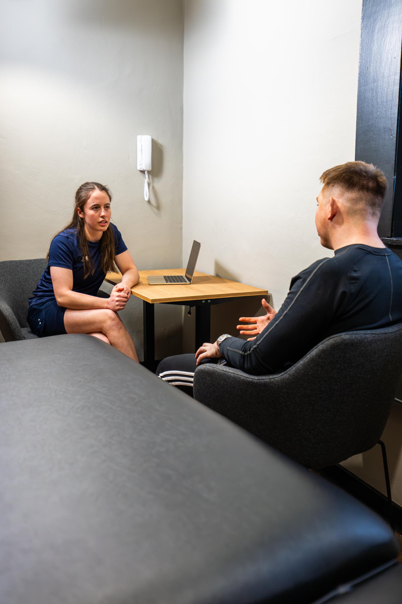 Specialist discussing rehabilitation protocols and exercise progressions with a patient in a private physiotherapy edinburgh treatment room.