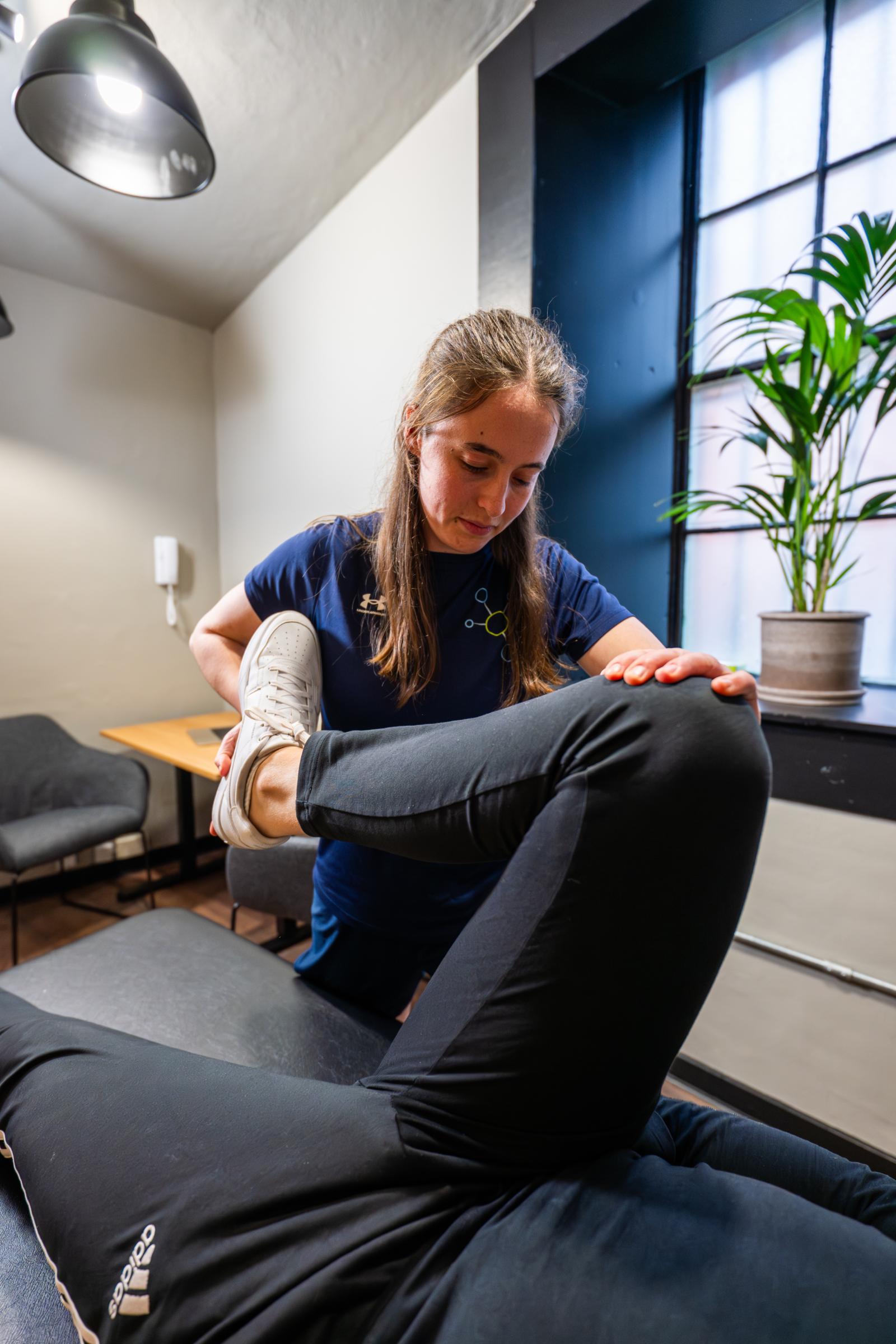 Health by Science female physiotherapist edinburgh performing a manual hip and lower limb stretch to support patient injury recovery in Edinburgh.