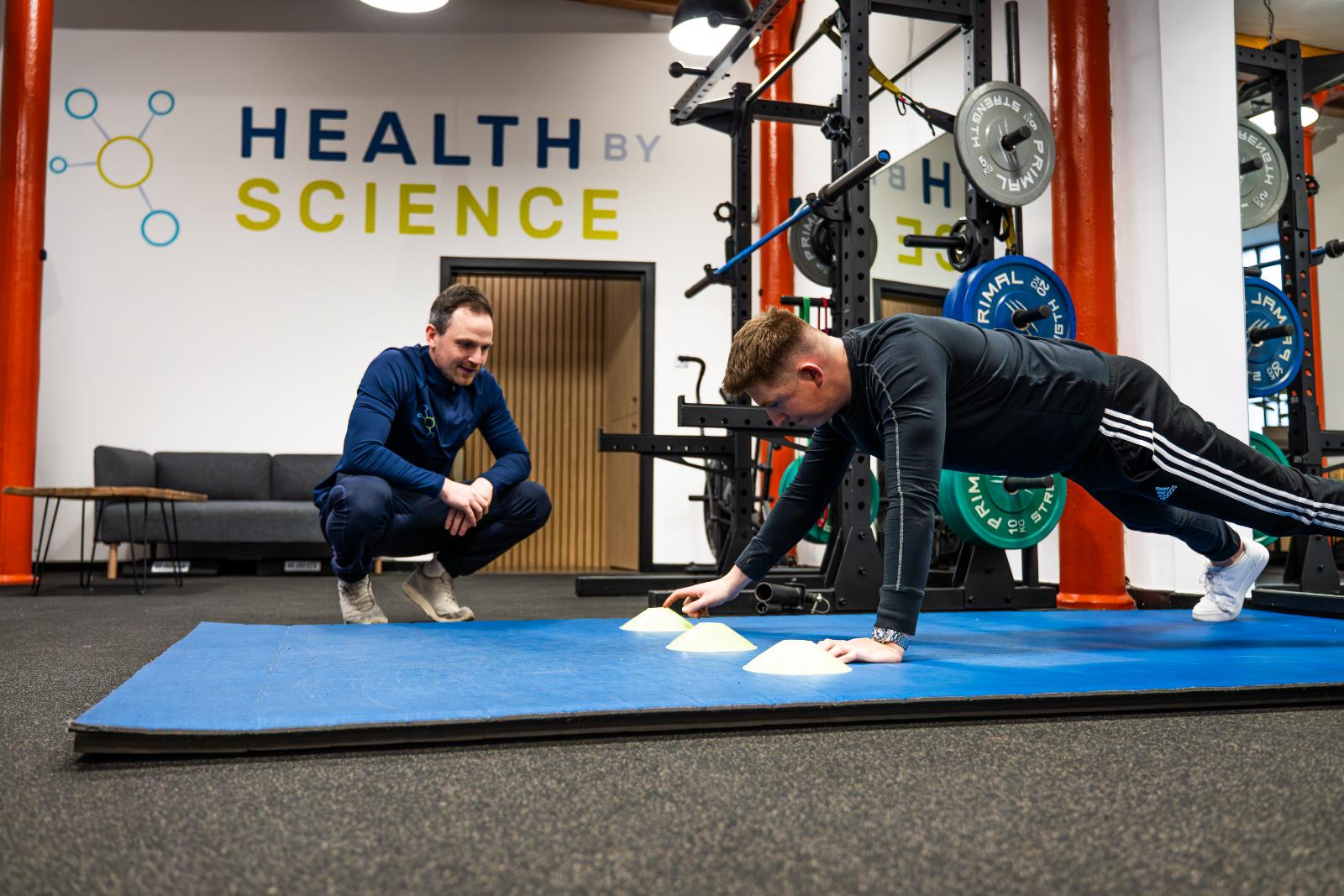Specialist provide expert movement analysis during a functional core exercise to support long-term injury prevention.